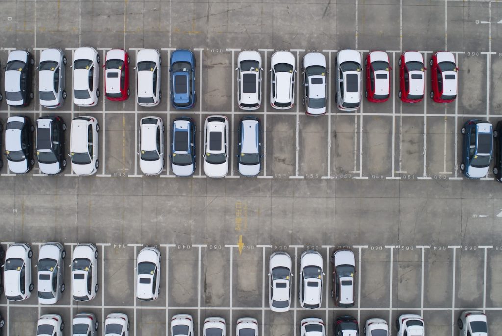 Személyautók egy parkolóban felülnézetből