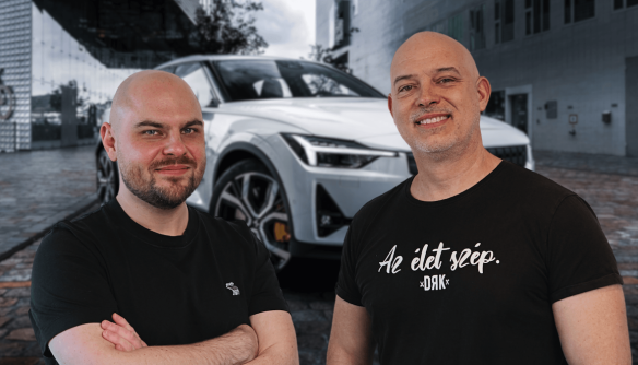 Lőcsei Dániel, a Használtautó.hu brand managere (balra) és Bertalan Gábor, az Autó Sámán (jobbra). A háttérben egy fehér Volvo autó látható.