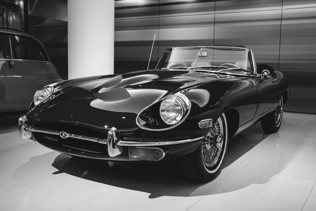 Fekete-fehér fotó egy Jaguar E-Type Roadster autóról.