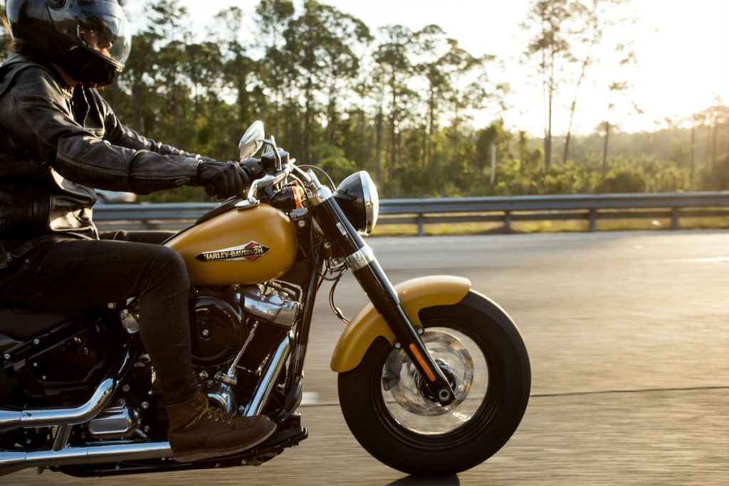 Egy Harley Davidson motoron utazik valaki a háttérben naplementével. Cikkünkben a legnépszerűbb motorok listáját gyűjtöttük össze.