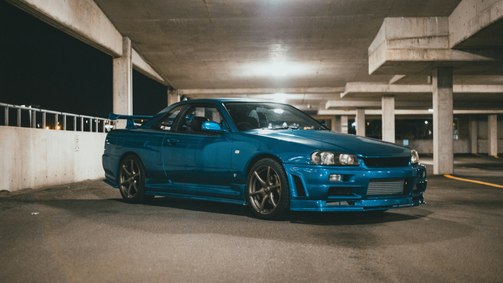 Kékszínű R34 GT-R egy üres parkolóházban