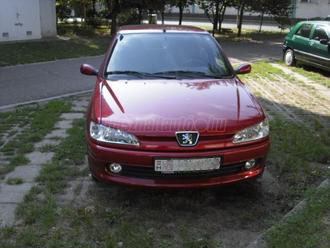 Piros Peugeot fotója. A motorháztetőn becsillan az ég, a visszatükröződő felhők és rányékok egyenetlen hatást keltenek.