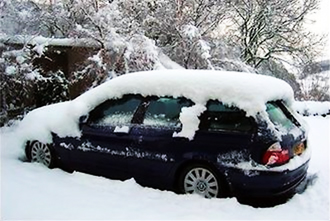 Sötétkék autó, aminek a tetején tíz centi hó áll. Az autó nagyrésze nem látható a hótól.
