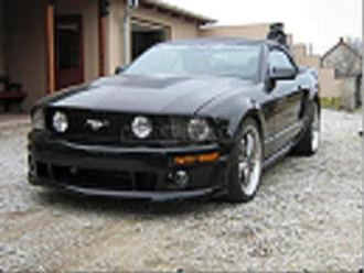 Pixeles, kis felbontású kép egy fekete Ford Mustangról.