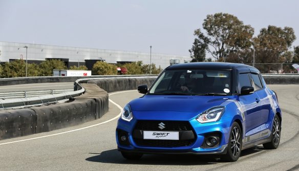 Kék Suzuki Swift egy kanyarodó úton.