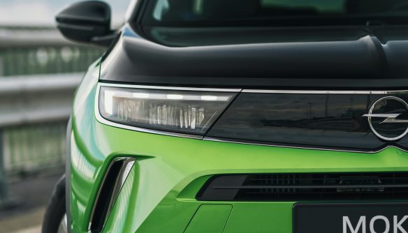 A képen egy zöld és fekete színű Opel Mokka látható szemből nézetből.