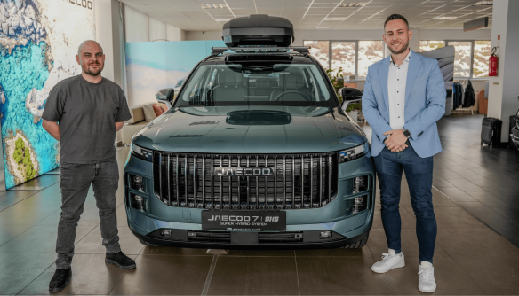 A Használtautó.hu GT videó borítóképe. Középen egy Jaecoo autó látható, amitől balra Lőcsei Dániel, jobbra pedig Izsó Péter áll.