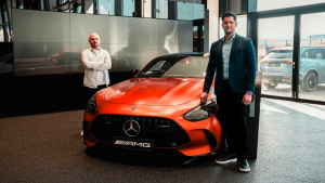 Lőcsei Dániel és Varga Gábor a Mercedes-Benz Miskolc vadonatúj márkakereskedésében, egy narancssárga Mercedes mellett.