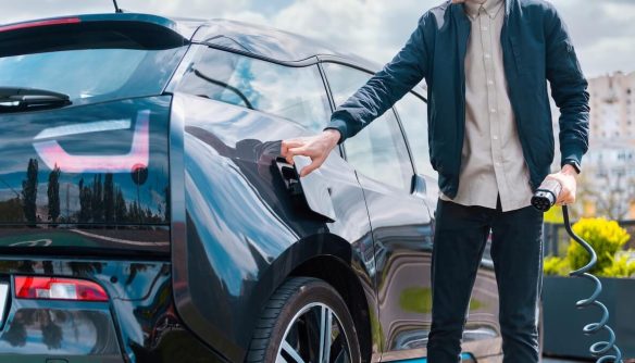 Egy férfi elektromos autót tölt.