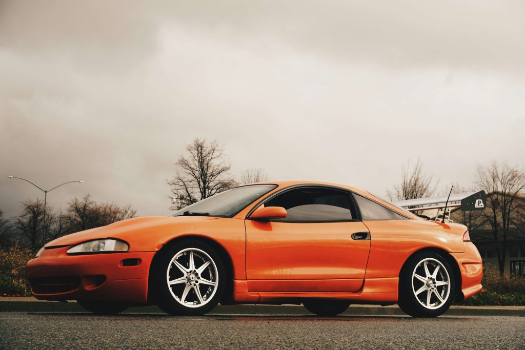 A képen egy narancssárga Mitsubishi Eclipse látható.