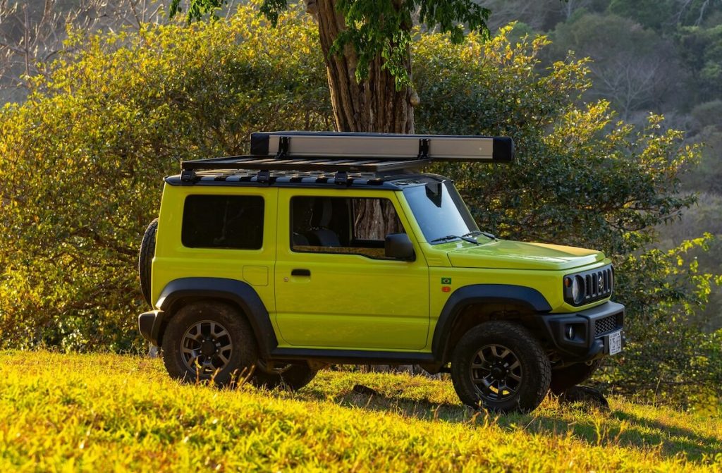 Sárga Suzuki Jimny egy sárga mezőn áll a napfényben.