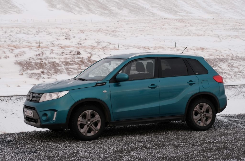 Kék Suzuki Vitara áll az úton, mögötte havas táj.