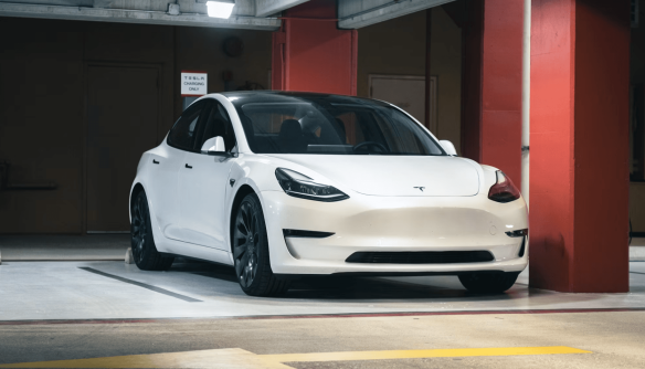 A képen egy fehér Tesla látható.