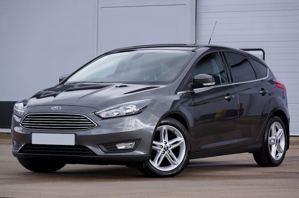 Fekete Ford Fiesta parkol egy szürke fal előtt