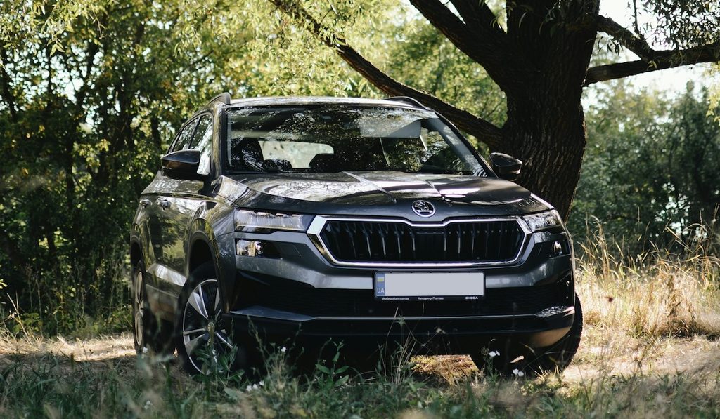 Fekete Skoda Karoq SUV egy fa árnyékában.