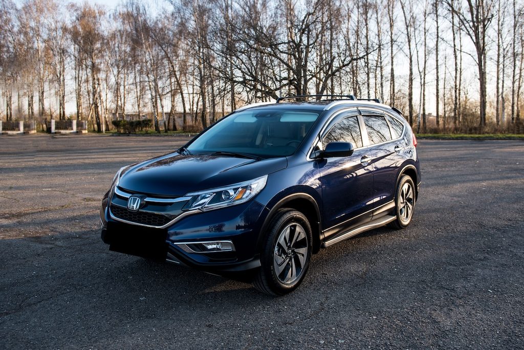 Sötétkék Honda CR-V SUV, mögötte őszi fák.