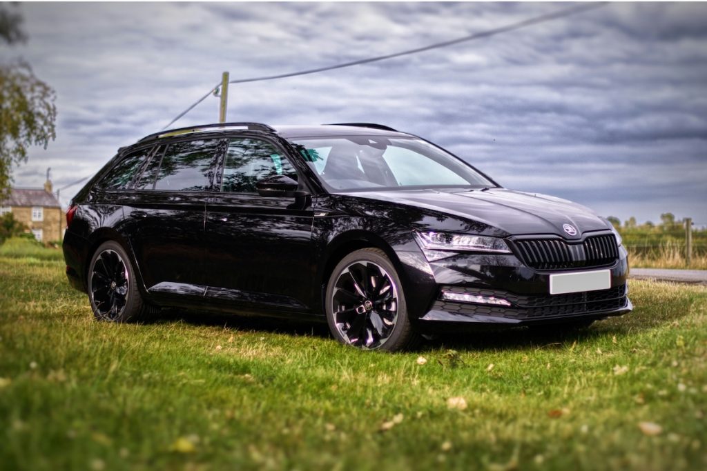 Fekete Skoda Superb egy mezőn.